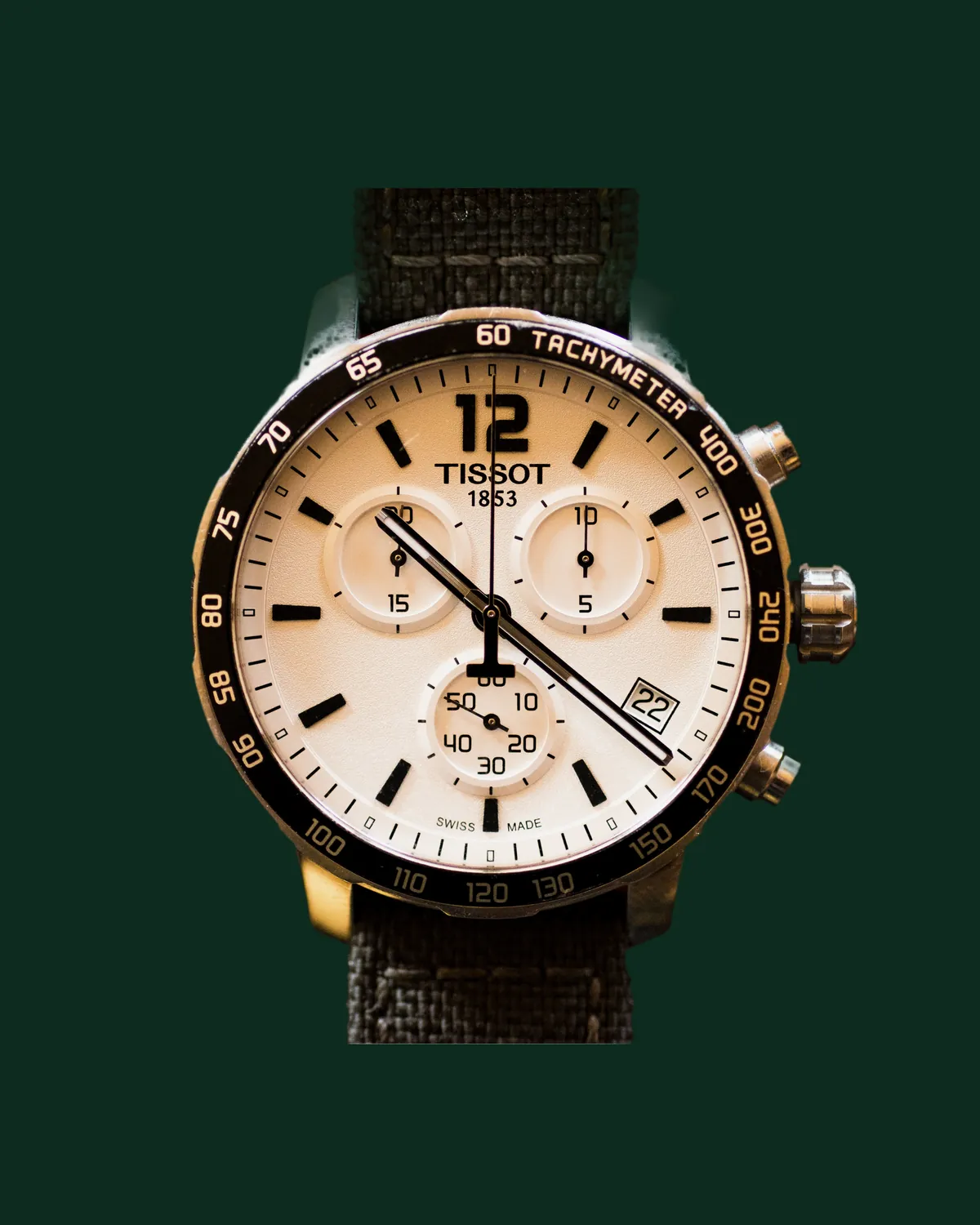A chronograph with a cream dial and a canvas strap